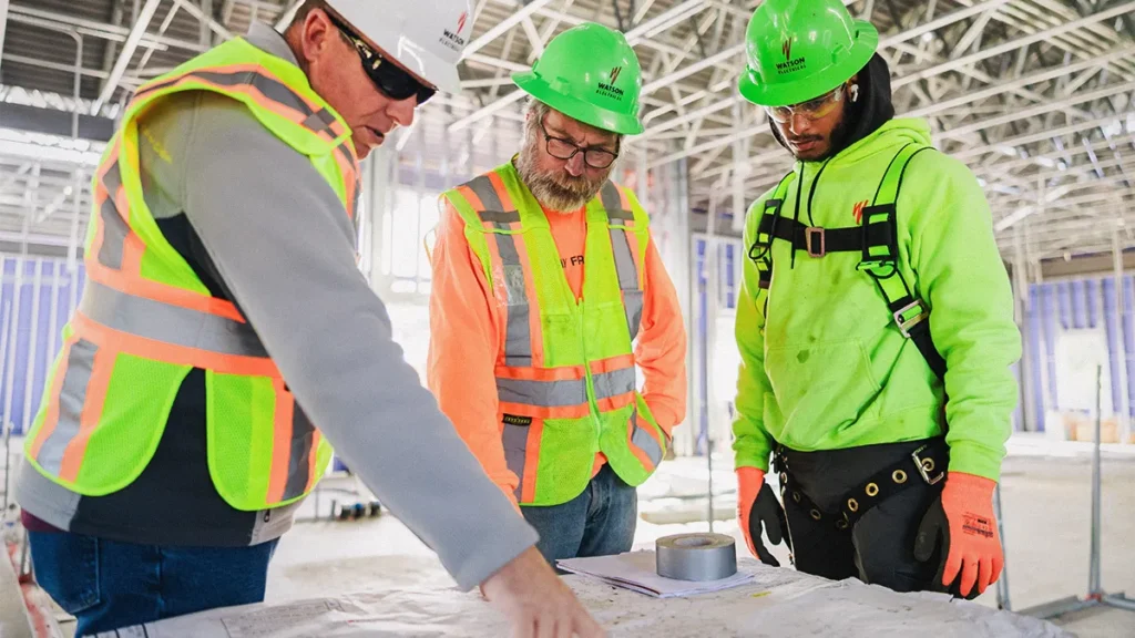 3 employees looking over job plans