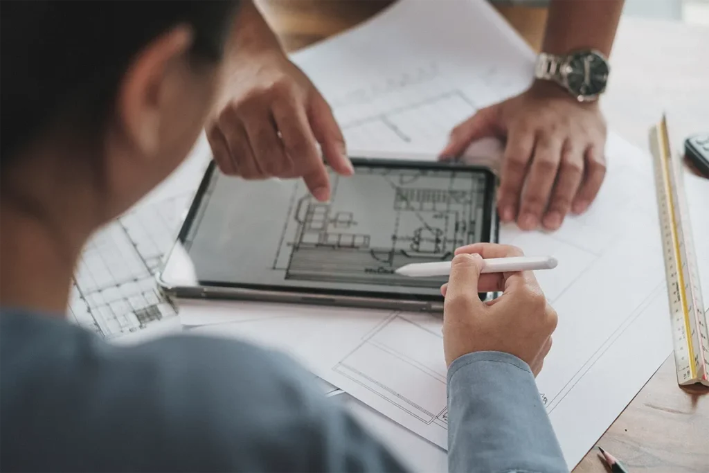 two workers reviewing plans on ipad
